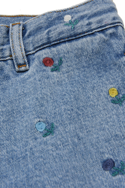 Jeans in denim celeste con fiori ricamati e patch per bambina